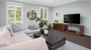 a living room with a couch and a tv at Idyllic Tui in Picton