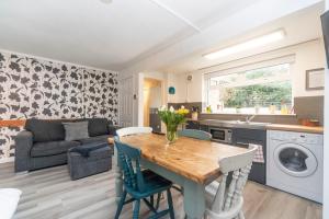 a kitchen and living room with a wooden table and chairs at 10 Boutique Studio Apartment near Tube - quiet location in Little Missenden +9 photos
