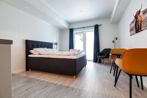 1 dormitorio con 1 cama, mesa y sillas en Stylish and serviced Studio apartment in Lofoten en Svolvær