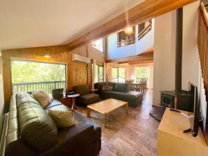 sala de estar con sofá y chimenea en Sublime Cedar Lodge Leura en Leura
