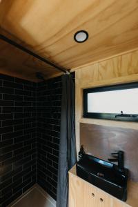 a bathroom with a sink and a black tiled wall at CABN Clare Valley in Mintaro