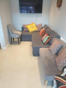 uma sala de estar com um sofá com almofadas em 2b Seymour road em Hackbridge