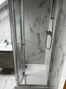 a shower with a glass door in a bathroom at 2b Seymour road in Hackbridge
