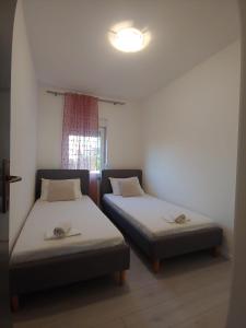 twee bedden in een kleine kamer met een raam bij Apartments with a parking space Povljana, Pag - 224 in Povljana