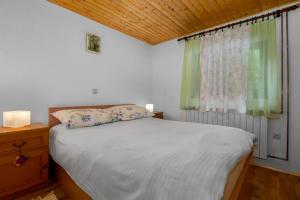 a bedroom with a white bed and a window at Holiday house with a swimming pool Breze, Novi Vinodolski - 20493 in Novi Vinodolski +17 photos
