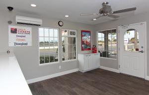 a living room with a ceiling fan and windows at Hotel 414 Anaheim in Anaheim