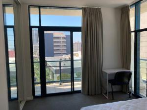 a hotel room with a desk and large windows at Sea View Full Apartment at Darwin City Heart in Darwin