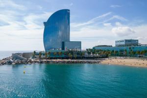 een uitzicht op een strand met een gebouw op de achtergrond bij W Barcelona in Barcelona