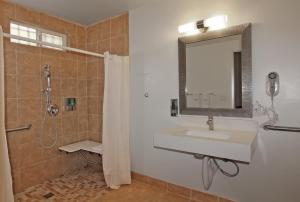 a bathroom with a sink and a shower with a mirror at Hotel 414 Anaheim in Anaheim