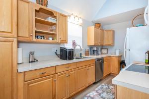 a kitchen with wooden cabinets and a white refrigerator at *4BR 2BA N Shore Hidden Retreat* in Roscommon