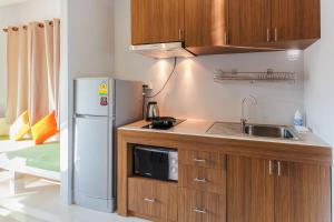 a small kitchen with a sink and a refrigerator at Happy Eight Resort in Nai Harn Beach +69 photos