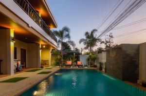 een zwembad in de achtertuin van een huis bij Happy Eight Resort SHA in Nai Harn Beach