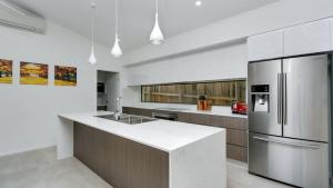 a kitchen with a stainless steel refrigerator and a counter at Parkview - Palm Cove in Palm Cove