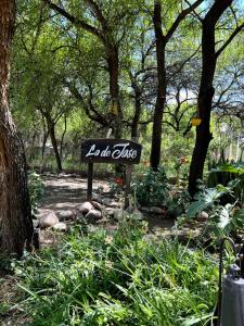 una señal en medio de un jardín con árboles en Finca Lo de Jose en La Banda