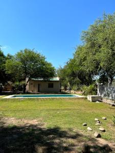 a swimming pool with a house and some trees at Finca Lo de Jose in La Banda