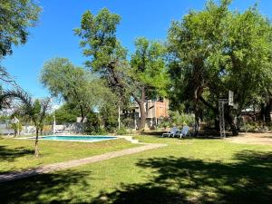 a yard with a swimming pool and trees and a house at Finca Lo de Jose in La Banda