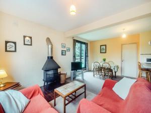 sala de estar con sofá rojo y chimenea en The Garden Lodge, en Broadhembury