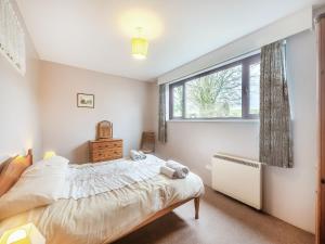 1 dormitorio con cama y ventana en The Garden Lodge, en Broadhembury