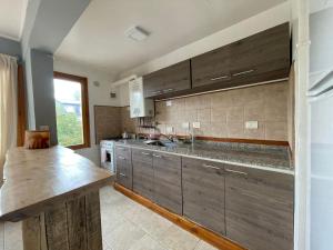 cocina con armarios de madera y encimera en Frambuesas Flat en Villa La Angostura