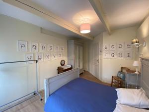 ein Schlafzimmer mit einem blauen Bett in einem Zimmer in der Unterkunft Stone house typical of the Pays de Rance, 900m from the beach in Le Minihic-sur-Rance