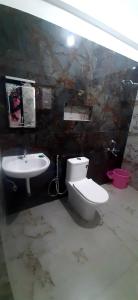 a bathroom with a toilet and a sink at ROYAL GRAND Homestay & Resort in Vālpārai