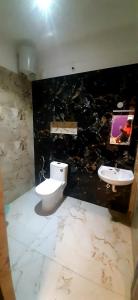 a bathroom with a toilet and a sink at ROYAL GRAND Homestay & Resort in Vālpārai