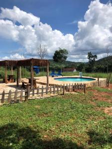 a swimming pool with a wooden fence around it at Recanto do Vale in Pirenópolis