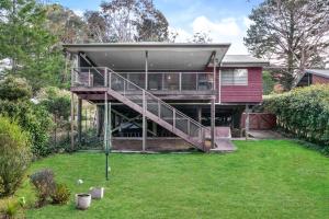 a house with a deck and a yard at Baileys Retreat in Leura