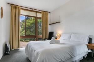 um quarto com uma grande cama branca e uma janela em Solitary View em Wentworth Falls