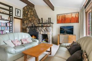 uma sala de estar com um sofá e uma lareira em Solitary View em Wentworth Falls
