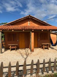 une petite maison avec une clôture devant elle dans l'établissement Recanto do Vale, à Pirenópolis