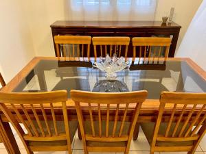 mesa de comedor con 4 sillas y mesa de cristal en Casa Bea, en Tela
