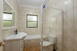 a bathroom with a toilet and a sink and a shower at Scenic Cottage in Katoomba +13 photos