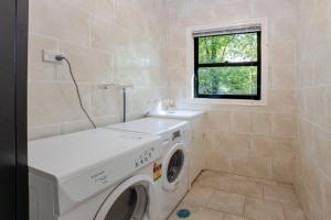 a laundry room with a washing machine and a window at Scenic Cottage in Katoomba