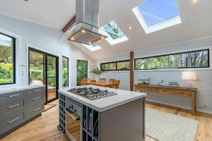 a kitchen with a stove and some windows at Leura Pines in Leura