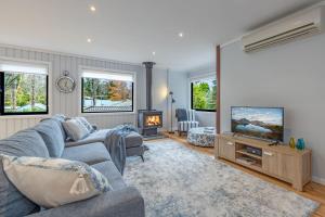 a living room with a couch and a tv at Leura Pines in Leura