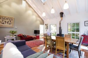 uma sala de estar com uma mesa e um sofá em White Cottage em Wentworth Falls