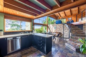 a kitchen with blue cabinets and a table with chairs at Grey Gum Lodge in Woodford