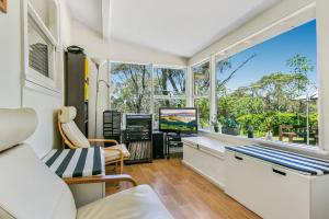 a living room with a large window and a tv at Lavender Cottage in Leura