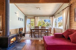 a living room with a fireplace and a table and chairs at Keira Cottage in Katoomba