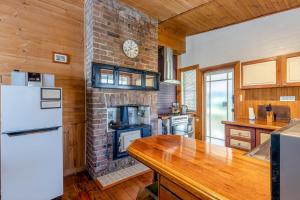 eine Küche mit einem gemauerten Kamin und einem Kühlschrank in der Unterkunft Keira Cottage in Katoomba + 16 Fotos
