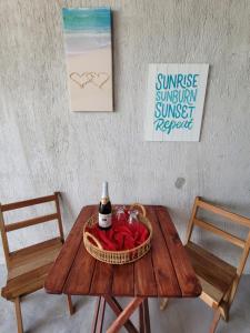 - une table avec une bouteille de vin et un panier de roses dans l'établissement Puerto del Cielo, à Chuburná