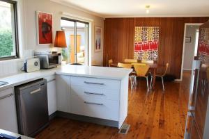 a kitchen with a white counter and a dining room at Highview in Leura