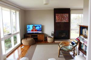 a living room with a television and a fireplace at Highview in Leura