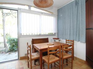uma sala de jantar com uma mesa de madeira e cadeiras em Appartement Argelès-sur-Mer, 2 pièces, 4 personnes - FR-1-309-255 em Argelès-sur-Mer