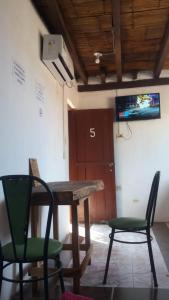 mesa y sillas en una habitación con TV en Hostal San Andrés de k-noa, en Canoa