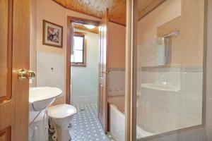 a bathroom with a toilet and a tub and a sink at Observatory Cottage in Leura +8 photos