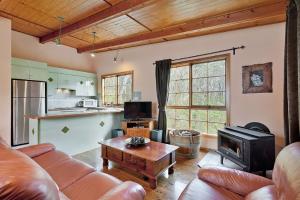 a living room with a couch and a stove at Observatory Cottage in Leura