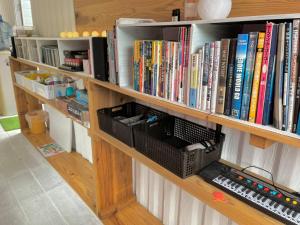 una estantería llena de libros en GUEST HOUSE SUMIRE - Vacation STAY 34298v, en Nago