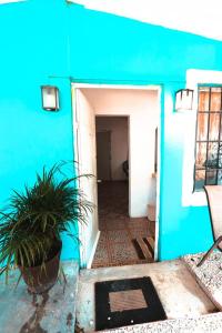 una casa azul con una planta en la puerta en Otoch Béek Calakmul, en Chicanna